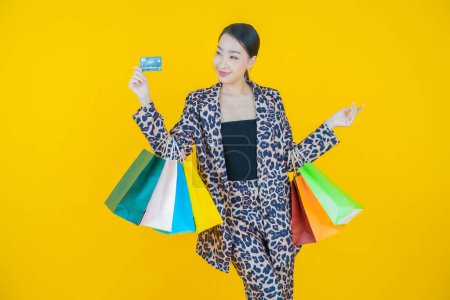 Foto de Retrato hermosa joven mujer asiática sonrisa con bolsa de compras en el fondo de color - Imagen libre de derechos