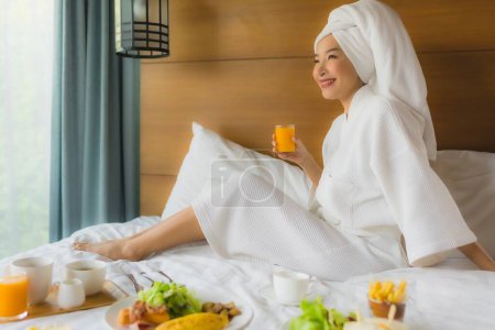 Foto de Retrato joven mujer asiática en la cama con desayuno en el interior del dormitorio - Imagen libre de derechos