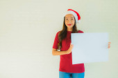 Portrait beautiful young asian women wear santa christmas hat show blank white board card with copy space Poster #624954690