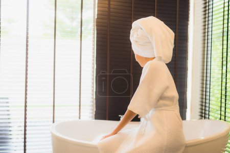 Téléchargez les photos : Portrait belle jeune femme asiatique sourire heureux relax prendre un bain dans la baignoire de salle de bain intérieur - en image libre de droit