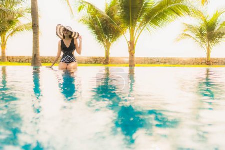Photo for Portrait beautiful young asian woman relax around outdoor swimming pool in hotel resort with palm tree at sunset or sunrise for leisure vacation - Royalty Free Image