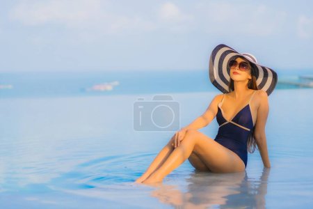 Foto de Retrato hermosa joven mujer asiática relajarse alrededor de la piscina en el complejo hotelero para el ocio en vacaciones - Imagen libre de derechos