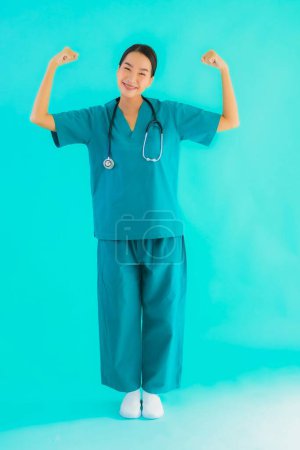 Foto de Retrato hermosa joven asiática médico mujer sonrisa con muchos acción en azul aislado fondo - Imagen libre de derechos