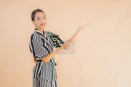 Téléchargez les photos : Portrait belle jeune femme asiatique sourire heureux sur fond brun isolé - en image libre de droit