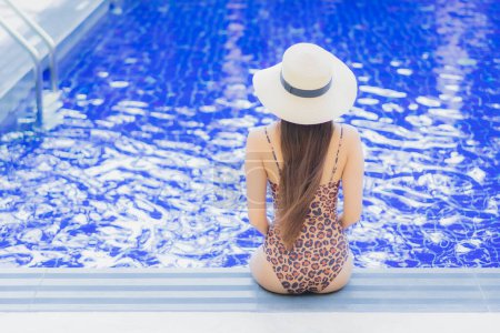 Foto de Retrato hermosa joven mujer asiática relajarse sonrisa ocio alrededor de la piscina al aire libre en vacaciones viajes de vacaciones - Imagen libre de derechos