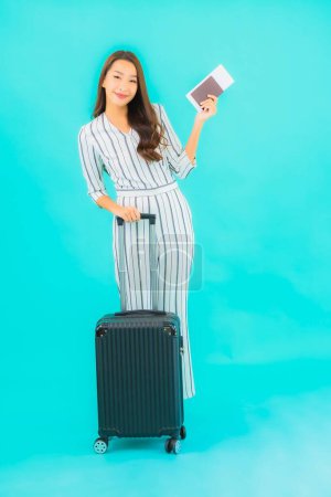 Téléchargez les photos : Portrait belle jeune femme asiatique avec passeport bagage et carte d'embarquement prêt pour voyager sur fond bleu - en image libre de droit