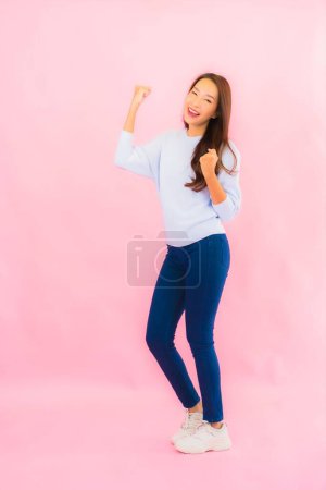 Foto de Retrato hermosa joven asiática mujer sonrisa con acción en rosa aislado fondo - Imagen libre de derechos