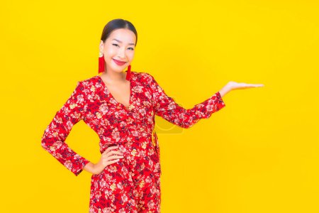 Foto de Retrato hermosa joven mujer asiática sonrisa en acción en chino nuevo concepto de año en el fondo de color - Imagen libre de derechos