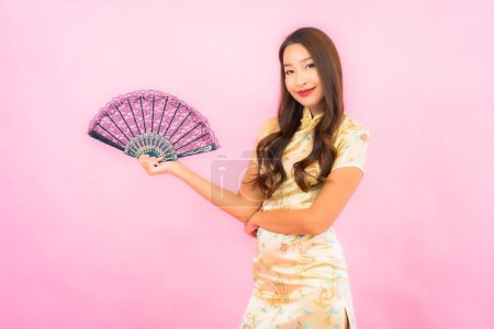 Téléchargez les photos : Portrait belle jeune femme asiatique avec le concept de nouvelle année chinoise et ventilateur sur fond de couleur - en image libre de droit