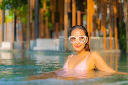 Téléchargez les photos : Portrait belle jeune femme asiatique relax sourire profiter des loisirs autour de la piscine en hôtel station - en image libre de droit