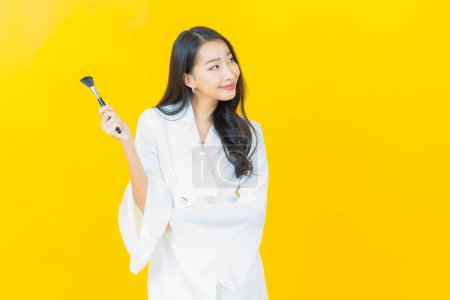 Photo for Portrait beautiful young asian woman with make up brush cosmetic on color background - Royalty Free Image