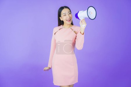 Foto de Retrato hermosa joven asiática mujer sonrisa con megáfono en color de fondo - Imagen libre de derechos