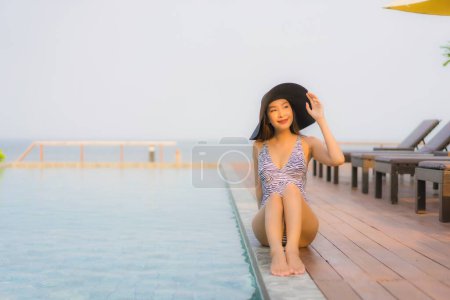 Photo for Portrait young asian woman happy smile relax around outdoor swimming pool in hotel resort for travel vacation - Royalty Free Image