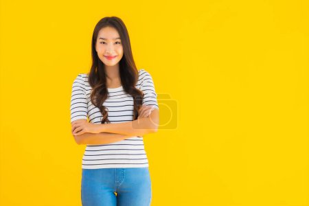 Foto de Retrato hermosa joven asiática mujer sonrisa feliz con acción sobre amarillo aislado fondo - Imagen libre de derechos