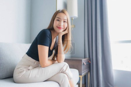 Photo for Portrait beautiful young asian woman sit on sofa relax in living room area - Royalty Free Image