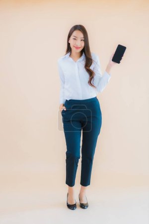 Téléchargez les photos : Portrait belle jeune femme asiatique d'affaires avec téléphone portable intelligent et tasse de café - en image libre de droit