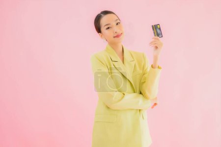 Foto de Retrato hermosa joven asiática mujer de negocios con tarjeta de crédito en color de fondo - Imagen libre de derechos