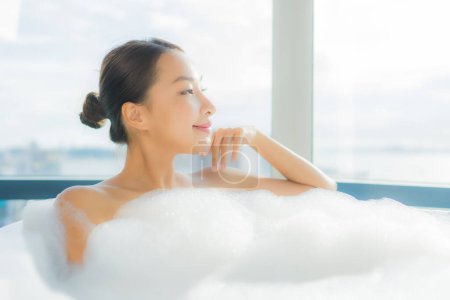 Foto de Retrato hermosa joven asiática mujer relajarse disfrutar en bañera en baño interior - Imagen libre de derechos