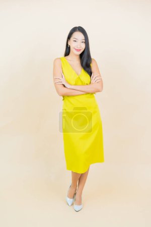 Téléchargez les photos : Portrait belle jeune femme asiatique sourire avec action sur fond crème - en image libre de droit
