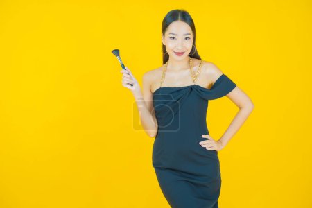 Photo for Portrait beautiful young asian woman with make up brush cosmetic on color background - Royalty Free Image