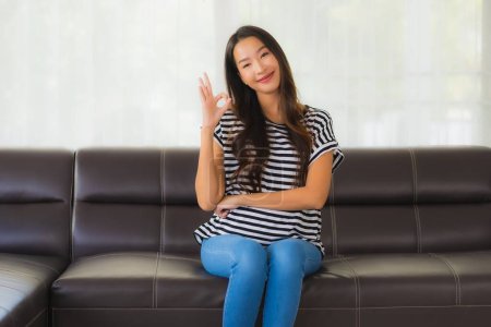 Photo for Portrait beautiful young asian woman happy smile relax on sofa in living room interior - Royalty Free Image