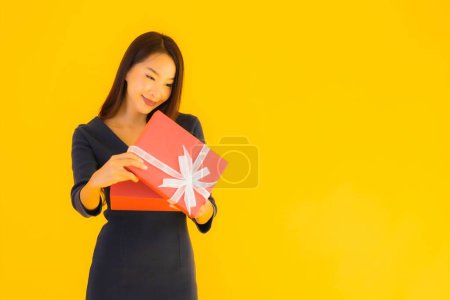 Photo for Portrait beautiful young asian woman with giftbox on yellow isolated background - Royalty Free Image