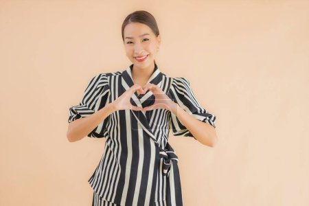 Téléchargez les photos : Portrait belle jeune femme asiatique sourire heureux sur fond brun isolé - en image libre de droit