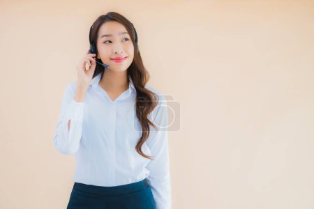 Téléchargez les photos : Portrait belle jeune femme d'affaires asiatique avec casque pour centre d'appel sur fond isolé couleur - en image libre de droit