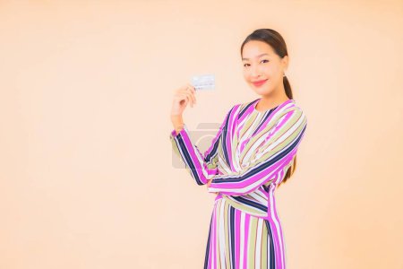 Foto de Retrato hermosa joven asiática mujer con teléfono móvil inteligente y tarjeta de crédito en color aislado fondo - Imagen libre de derechos