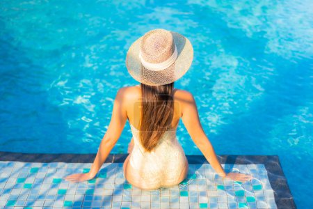 Foto de Retrato hermosa joven asiática mujer relajarse sonrisa ocio en vacaciones alrededor de la piscina en resort hotel - Imagen libre de derechos
