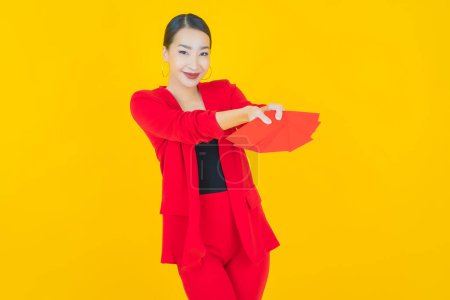 Photo for Portrait beautiful young asian woman with red envelope on color background - Royalty Free Image
