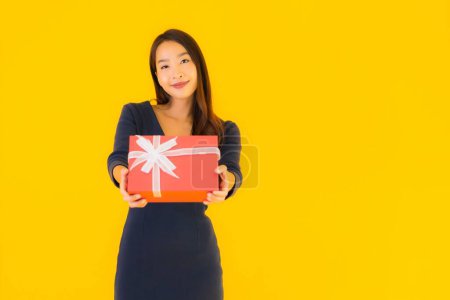 Foto de Retrato hermosa joven asiática mujer con giftbox en amarillo aislado fondo - Imagen libre de derechos