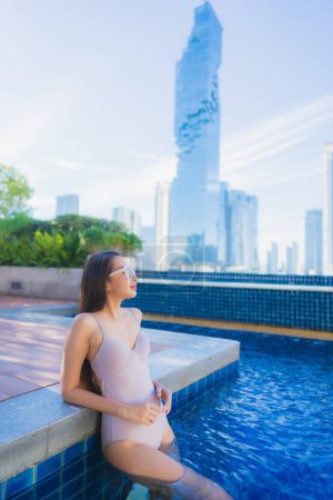 Foto de Retrato hermosa joven mujer asiática relajarse ocio disfrutar alrededor de piscina al aire libre en vacaciones - Imagen libre de derechos