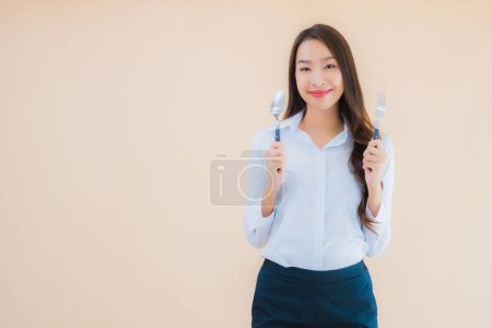 Téléchargez les photos : Portrait belle jeune femme d'affaires asiatique avec cuillère et fourchette prête à manger - en image libre de droit