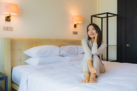 Foto de Retrato hermosa joven mujer asiática sonrisa feliz relajarse en la cama en el interior del dormitorio - Imagen libre de derechos
