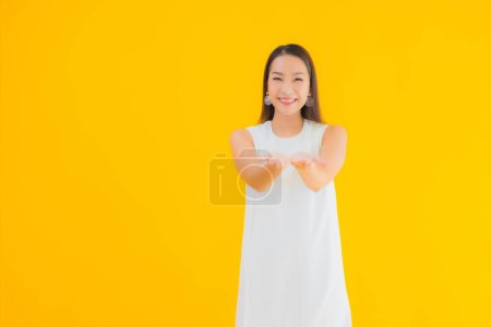 Téléchargez les photos : Portrait belle jeune femme asiatique en action sur fond jaune isolé - en image libre de droit