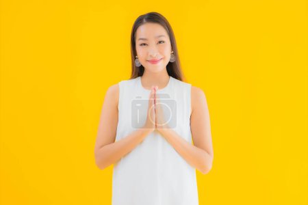 Téléchargez les photos : Portrait belle jeune femme asiatique en action sur fond jaune isolé - en image libre de droit