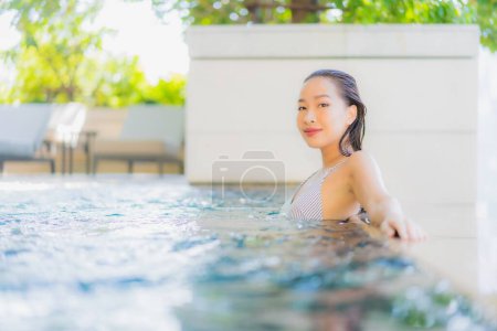 Téléchargez les photos : Portrait belle jeune femme asiatique sourire détendre loisirs autour de la piscine pour les vacances - en image libre de droit