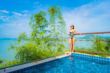 Photo for Portrait beautiful young asian woman relax smile leisure around outdoor swimming pool with sea ocean view for travel vacation - Royalty Free Image