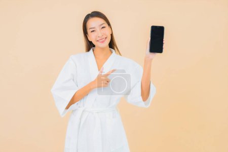 Photo for Portrait beautiful young asian woman use smart mobile phone on color isolated background - Royalty Free Image