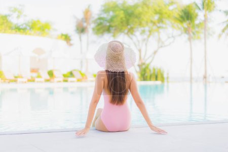 Téléchargez les photos : Portrait belle jeune femme asiatique se détendre loisirs autour de la piscine extérieure avec vue sur la mer plage océan en vacances Voyage - en image libre de droit