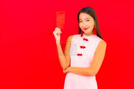 Foto de Retrato hermosa joven mujer asiática con sobre rojo letra sobre fondo rojo - Imagen libre de derechos