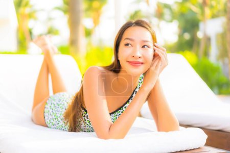 Foto de Retrato hermosa joven asiática mujer relajarse sonrisa disfrutar de ocio alrededor de la piscina en resort hotel de vacaciones - Imagen libre de derechos