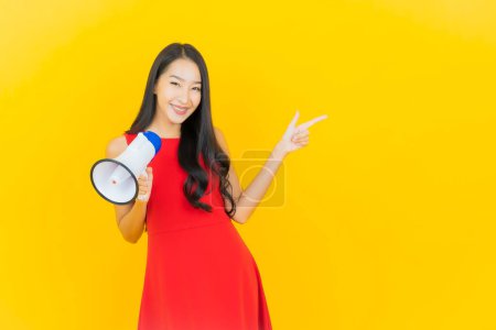 Photo for Portrait beautiful young asian woman smile with megaphone on yellow color background - Royalty Free Image