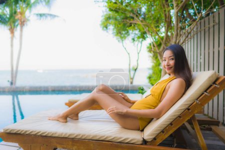 Foto de Retrato hermosa joven asiático mujeres feliz sonrisa relajarse alrededor de piscina al aire libre en hotel resort para vacaciones de viaje - Imagen libre de derechos