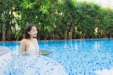 Photo for Beautiful portrait young asian woman happy smile relax around swimming pool in resort hotel for leisure - Royalty Free Image