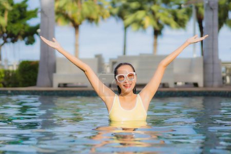 Téléchargez les photos : Portrait belle jeune femme asiatique relax sourire loisirs autour de la piscine extérieure en vacances vacances voyages - en image libre de droit