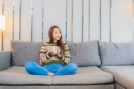 Photo for Portrait beautiful young asian woman sit smile relax on sofa in living room interior - Royalty Free Image