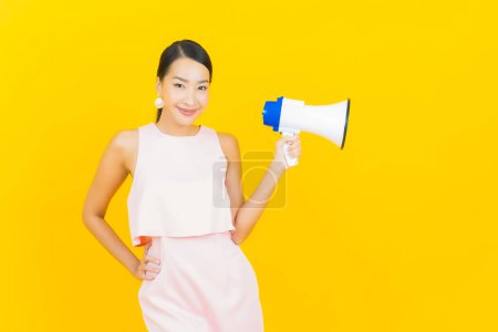 Photo for Portrait beautiful young asian woman smile with megaphone on yellow color background - Royalty Free Image