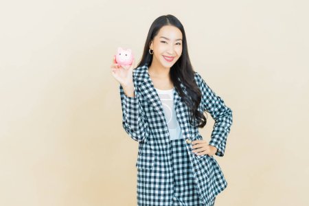 Photo for Portrait beautiful young asian woman with piggy bank on color background - Royalty Free Image
